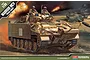 Box art for an Academy 1/35 scale Desert Warrior MCV model kit, featuring an illustration of a tan armoured vehicle in a desert combat scene.