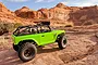 A bright green Axial SCX10 Deadbolt RC rock crawler parked on a rocky desert landscape with red sandstone cliffs in the background.