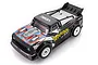 A high-angle studio shot of the UDI Breaker 1/16 scale RC truck, featuring a black body with red and blue racing decals and white wheels.
