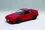 A completed 1/24 scale red Toyota MR2 AW11 plastic model car on a plain white background.