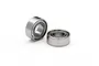 Two small metal shielded ball bearings sitting on a white surface.