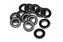 A pile of twelve small black metal washers arranged on a white background.