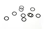 A collection of small, thin, circular metal washers scattered on a plain white background.