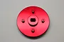 A red anodized aluminium spur gear adapter for HPI Baja 5B RC cars, featuring a circular plate with a central mounting hole and four smaller screw posts.