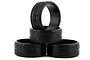 A set of four black RC drift tyres stacked against each other on a white background.