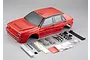 A red 1/10 scale Lancia Delta HF Integrale RC car body shell with various plastic accessory parts and decals laid out on a grey background.