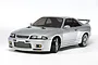 A silver Tamiya Nissan Skyline GT-R R33 RC drift car model on a white background, showing the front three-quarter view.