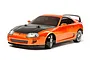 A 1/10 scale Tamiya Toyota Supra RC drift car with a metallic orange body and carbon fiber style hood on a white background.