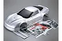 A silver painted 1/7 scale Corvette GT2 RC car body shell with included decal sheet, instruction manual, and small plastic accessory bags.