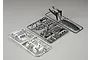 Two plastic model kit sprues for a 1/10 scale RC car, one with chrome-plated parts and one with matte black parts, on a grey background.