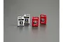 Four miniature scale model oil cans, two silver Mobil 1 bottles and two red Shell Helix HX3 bottles, arranged on a grey surface.