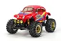 A studio shot of a Tamiya Monster Beetle 1/10 scale RC buggy, featuring a red Volkswagen Beetle-style body, oversized knobby tires, and gold-colored wheels.