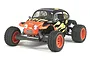 Tamiya Blitzer Beetle RC buggy with black body, orange flames, and orange wheels on a white background.