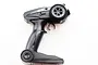 A black pistol-grip style RC transmitter with a steering wheel and throttle trigger on a white background.