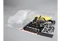 Unpainted clear polycarbonate RC car body shell with black plastic accessory parts and decal sheet for a 1/10 scale Nissan GT-R model.