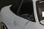 Close-up of a black racing-style side mirror mounted on a light grey RC car body shell.