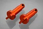 Two orange anodized aluminium mounting posts for RC vehicles, featuring a cylindrical body with a slotted base and a hole at the top.