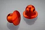 Two orange anodized aluminium RC body shell posts with a rounded top and side hole, displayed on a reflective grey surface.
