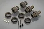 A set of gun metal coloured aluminium RC wheel hubs, locking nuts, pins, and small screws arranged on a grey reflective surface.