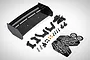 A Rovan black GT wing kit including a black plastic wing, mounting brackets, screws, nuts, body clips, and Baha 5B decal sheet.