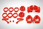 A set of bright red plastic RC car suspension parts including hub carriers, steering knuckles, and spacers arranged on a white background.