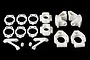 A set of white plastic RC car hub and suspension components arranged on a black background.