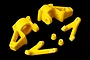 A set of bright yellow Rovan nylon front steering hub components and associated parts on a black background.