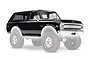 A black 1969 Chevrolet Blazer RC body shell for a Traxxas TRX-4, shown mounted on wheels and tires against a white background.