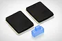 Losi 8B and 8T switch cover and foam pad set including two rectangular black foam pads and one translucent blue rubber switch cover.