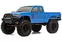 A blue Axial SCX10 III Base Camp 1/10 scale RC rock crawler truck viewed from a front three-quarter angle against a white background.