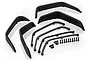 A set of four black plastic RC car fender flares with matching mounting brackets and small black screws arranged on a white background.