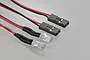 Two clear LED lights connected to red and black wires with black plastic servo-style connectors on a light grey background.