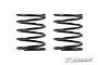 Two black linear RC shock springs standing side by side against a white background.