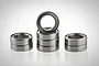 A set of eight metal shielded ball bearings arranged in three stacks against a white background.