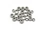 A collection of twenty metal ball bearings of varying sizes scattered on a white background.