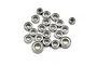 A collection of twenty small metal ball bearings of various sizes scattered on a white background.