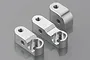 Three silver aluminium RC chassis brace mounts arranged on a grey reflective surface.