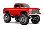 A bright red Traxxas TRX-4 1979 Chevrolet K10 Cheyenne RC truck with large off-road tires and a lifted suspension on a white background.