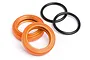 Two orange anodized aluminium shock spring adjuster nuts and two black rubber O-rings on a white background.
