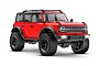 A studio shot of a bright red Traxxas TRX-4M Ford Bronco RC rock crawler on a white background, showing off-road tires and detailed bodywork.