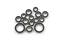 A collection of various sized steel ball bearings with black rubber seals for RC cars, arranged on a white background.