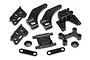 A set of black plastic RC car spare parts including chassis braces, bulkhead mounts, and small washers on a white background.
