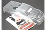 Clear, unpainted Traxxas T-Maxx RC truck body shell with a decal sheet on a dark background.