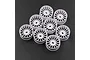 A set of eight white plastic RC car rims with a multi-spoke design arranged on a dark textured surface.