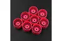 Eight fluorescent pink multi-spoke RC car rims arranged on a dark textured surface.