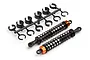 Two HPI Racing RC shock absorbers with black springs and orange collars, alongside a plastic tree of suspension spacers on a white background.