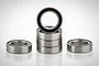 A set of six RGT rubber shielded ball bearings arranged with four stacked vertically and two placed flat on either side against a white background.