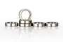 A set of five silver metal ball bearings arranged on a white reflective surface.