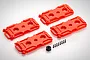 Four red plastic scale fuel tank accessories for RC crawler vehicles, accompanied by a small black nut and eight tiny black screws on a white background.