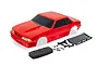 Traxxas 1/10 scale red Ford Mustang Fox body shell with included black rear wing, foam bumper, side mirrors, and mounting hardware on a white background.